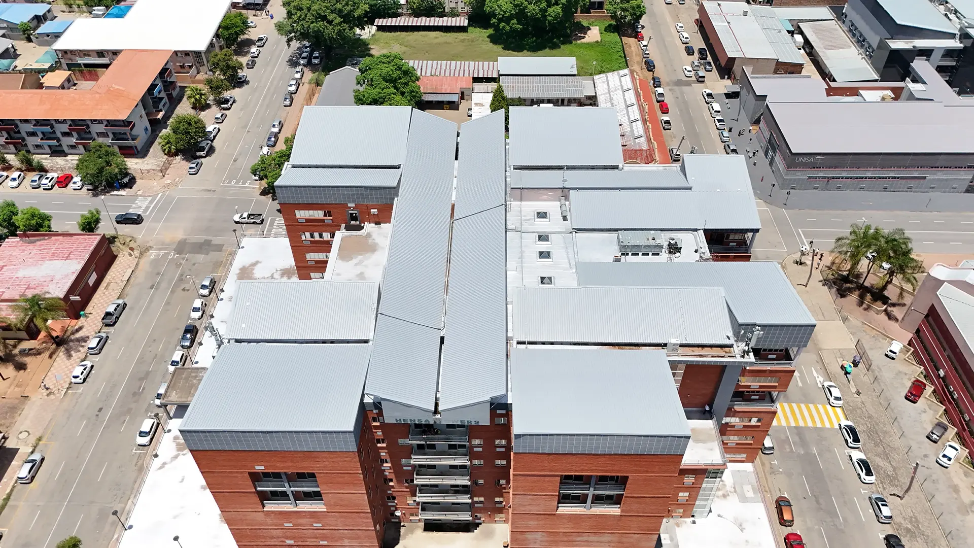 Drone image of a multi-level commercial building with completed roof restoration in an urban area