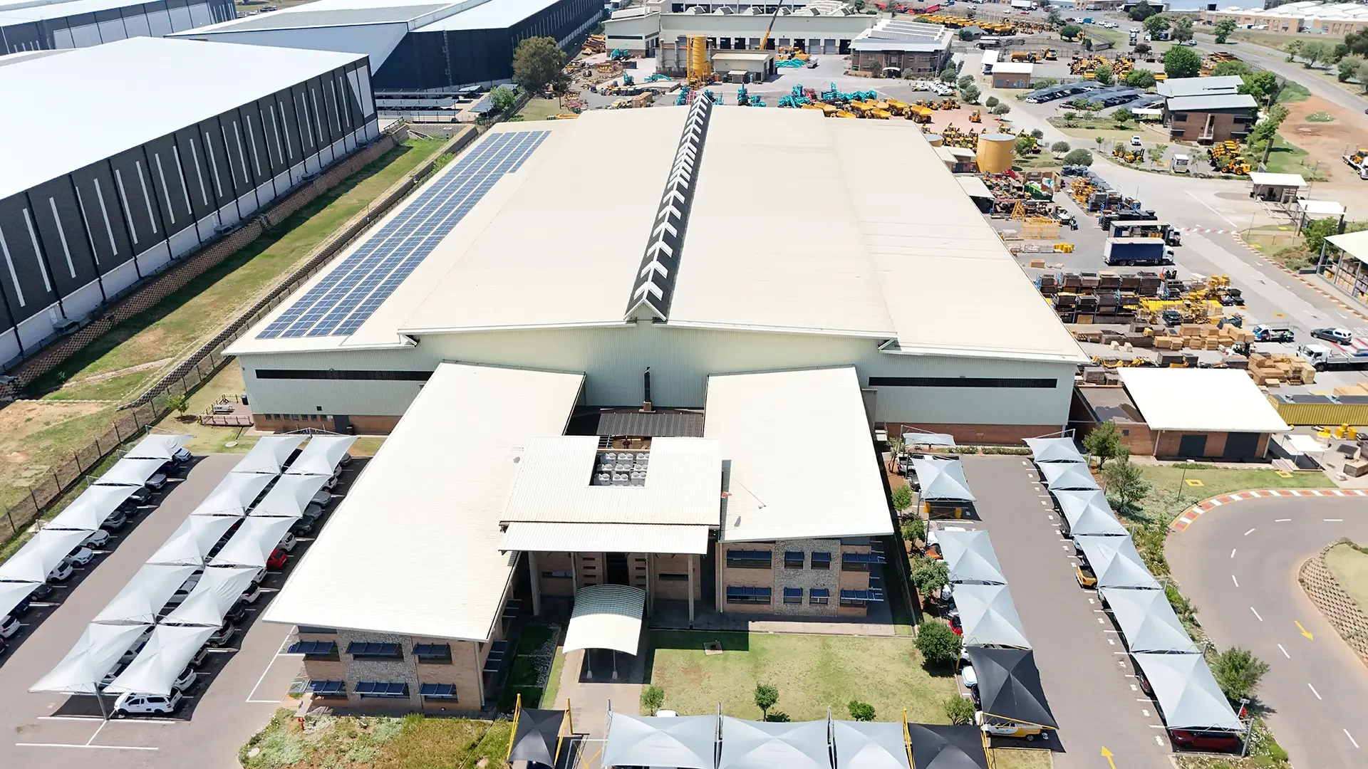 Aerial view of an industrial building with restored roof surfaces and solar panels after roof restoration
